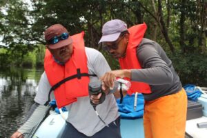 Myles Phillips and Kenneth Gale with WCS-Belize taking water quality measurements with a YSI near the mouth of the Belize River. 